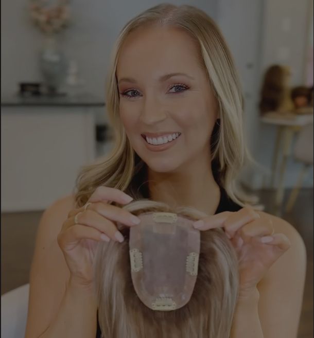 Smiling client holding a clip-in topper